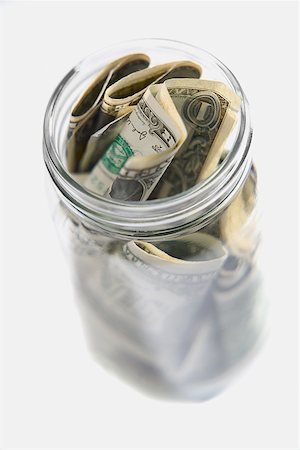 Dollar bills squashed into a jar Stock Photo - Premium Royalty-Free, Code: 625-01260975