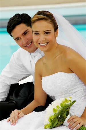 swimming formal dress - Close-up of a newlywed couple sitting at the poolside and smiling Stock Photo - Premium Royalty-Free, Code: 625-01261161