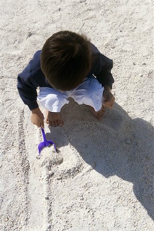 High angle view of a boy playing in the sand Stock Photo - Premium Royalty-Free, Code: 625-01261370