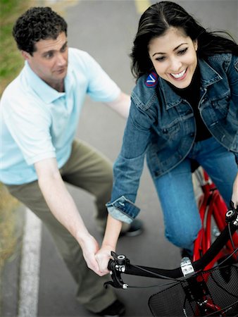 simsearch:625-01095436,k - High angle view of a mid adult man helping a mid adult woman ride a bicycle Stock Photo - Premium Royalty-Free, Code: 625-01261443