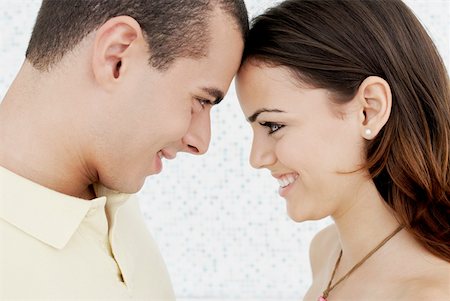 Close-up of a young couple looking at each other and smiling Stock Photo - Premium Royalty-Free, Code: 625-01261591