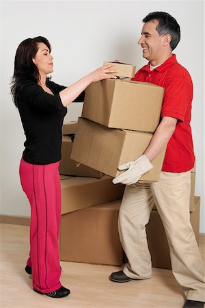 Side profile of a mid adult woman helping a mid adult man hold cardboard boxes Stock Photo - Premium Royalty-Free, Code: 625-01261881
