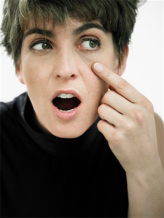 Close-up of a mature woman pointing towards her eye Stock Photo - Premium Royalty-Free, Code: 625-01261927