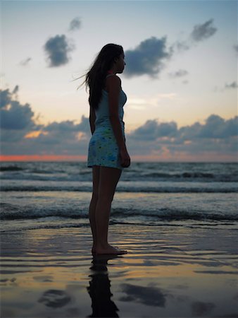 Side profile of a teenage girl standing on the beach Stock Photo - Premium Royalty-Free, Code: 625-01261962