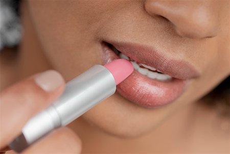 Close-up of a young woman applying lipstick Stock Photo - Premium Royalty-Free, Code: 625-01262135