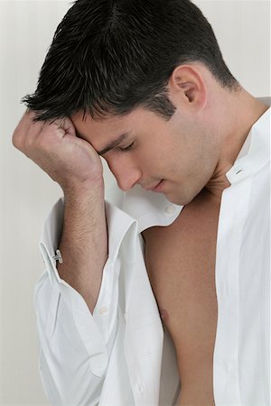 Close-up of a young man thinking with his hand on his forehead Stock Photo - Premium Royalty-Free, Code: 625-01262209