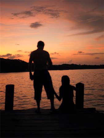silhouette people sitting on a dock - Silhouette of a man and a woman on a pier Foto de stock - Sin royalties Premium, Código: 625-01262409