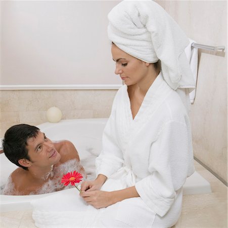 Woman taking bath, man sitting on side of bathtub, looking down at woman -  Stock Photo - Masterfile - Premium Royalty-Free, Code: 695-03381854