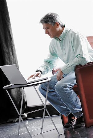 draperies glass - Side profile of a businessman using a laptop Stock Photo - Premium Royalty-Free, Code: 625-01262705