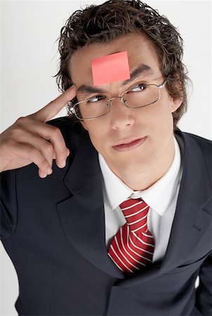 eyeglasses forehead - High angle view of a businessman with an adhesive note on his forehead Stock Photo - Premium Royalty-Free, Code: 625-01262830