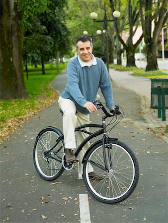 Portrait of a mature man riding a bicycle in the park Stock Photo - Premium Royalty-Free, Code: 625-01262860