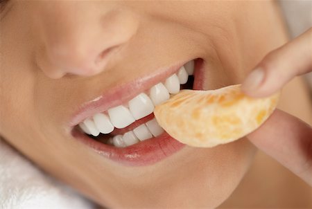 Close-up of a young woman eating an orange Stock Photo - Premium Royalty-Free, Code: 625-01262908
