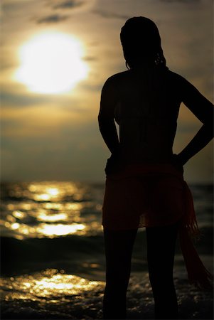 Silhouette of a young woman standing on the beach Stock Photo - Premium Royalty-Free, Code: 625-01263018