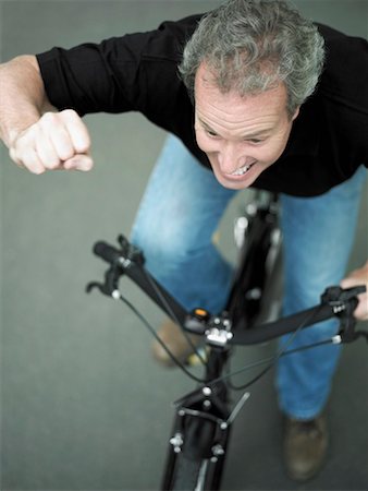 simsearch:625-01265118,k - High angle view of a mature man cycling with his hand raised Fotografie stock - Premium Royalty-Free, Codice: 625-01263025