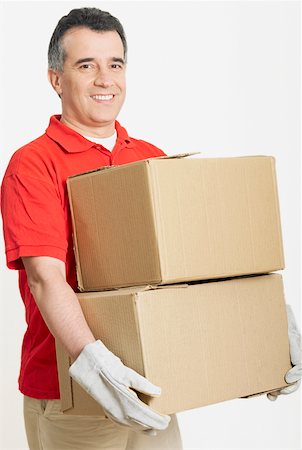 Portrait of a mid adult man holding cardboard boxes Stock Photo - Premium Royalty-Free, Code: 625-01263118