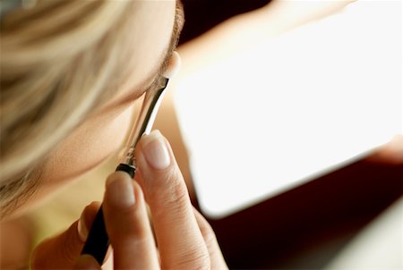 Close-up of a young woman applying eyeshadow Stock Photo - Premium Royalty-Free, Code: 625-01263232