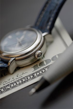 simsearch:625-01252456,k - Gros plan d'une montre-bracelet avec un stylo sur un billet de cent dollars Photographie de stock - Premium Libres de Droits, Code: 625-01263245