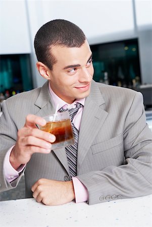 Close-up of a businessman holding a glass of cocktail in a bar Stock Photo - Premium Royalty-Free, Code: 625-01263318