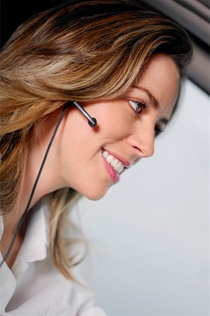 Close-up of a young woman wearing a hands free device and listening to music Stock Photo - Premium Royalty-Free, Code: 625-01263349