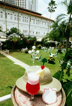 Singapore sling with a hat on a table in a garden, Raffles Hotel, Singapore city, Singapore Stock Photo - Premium Royalty-Free, Code: 625-01263842