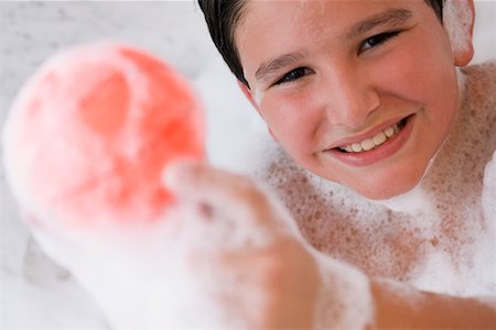 simsearch:625-00902119,k - Portrait d'un garçon tenant une boule dans une baignoire et souriant Photographie de stock - Premium Libres de Droits, Code: 625-01263982