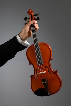 simsearch:625-00802645,k - Close-up of a musician's hand holding a violin Fotografie stock - Premium Royalty-Free, Codice: 625-01744015