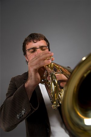 simsearch:625-00802645,k - Male musician playing a trumpet Fotografie stock - Premium Royalty-Free, Codice: 625-01744027