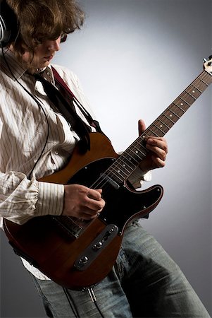 Close-up of a male guitarist playing a guitar Stock Photo - Premium Royalty-Free, Code: 625-01744045