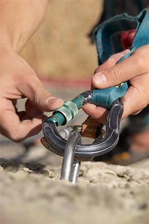 extreme rock climbing close up - Rock climber concording a carabiner with a hook Stock Photo - Premium Royalty-Free, Code: 625-01744186