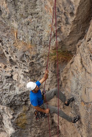 simsearch:625-01040859,k - High angle view of a male rock climber scaling a rock face with a rope Stock Photo - Premium Royalty-Free, Code: 625-01744200