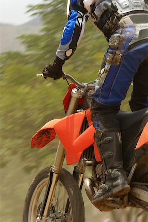 pista de terra - Low angle view of a motocross rider riding a motorcycle Foto de stock - Royalty Free Premium, Número: 625-01744280