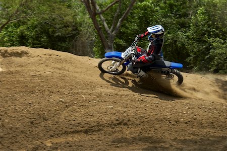 pista de terra - Side profile of a motocross rider riding a motorcycle Foto de stock - Royalty Free Premium, Número: 625-01744332