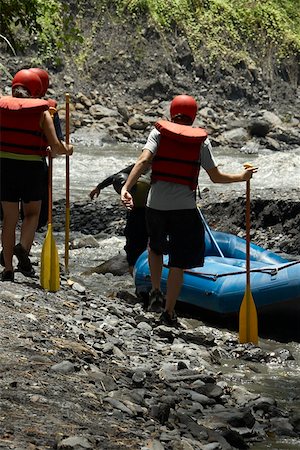 simsearch:614-01171527,k - Four people walking towards an inflatable raft at a riverside Fotografie stock - Premium Royalty-Free, Codice: 625-01744602