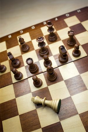 fallen king chess pieces - High angle view of chess game with a fallen king Stock Photo - Premium Royalty-Free, Code: 625-01744809