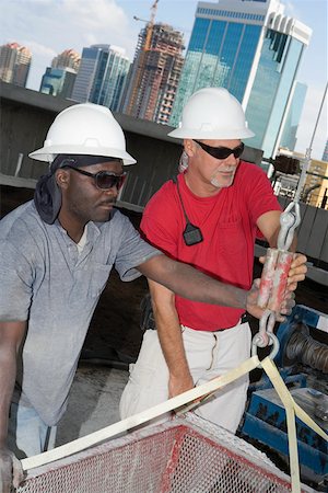 Close-up of two male construction workers working at a construction site Stock Photo - Premium Royalty-Free, Code: 625-01745793