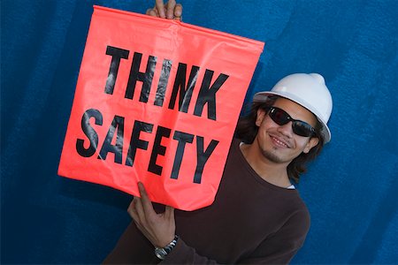 simsearch:625-01745814,k - Close-up of a male construction worker smiling and holding a warning sign Stock Photo - Premium Royalty-Free, Code: 625-01745854