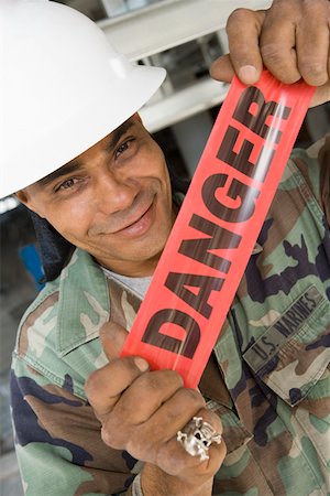 simsearch:625-01745814,k - Portrait of a male construction worker holding a cordon tape and smirking Stock Photo - Premium Royalty-Free, Code: 625-01745850