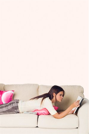 simsearch:625-02931506,k - Side profile of a young woman lying on a couch and reading a book Stock Photo - Premium Royalty-Free, Code: 625-01746364