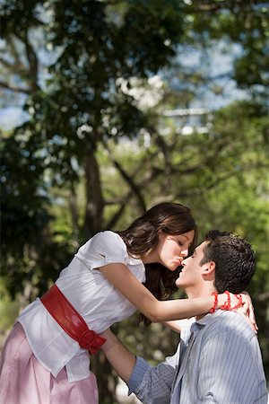 simsearch:625-01747094,k - Profil de côté d'un jeune couple romancing dans un parc Photographie de stock - Premium Libres de Droits, Code: 625-01746378