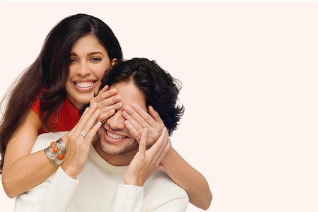 simsearch:625-01746515,k - Portrait of a young woman covering eyes of a young man from behind Fotografie stock - Premium Royalty-Free, Codice: 625-01746508