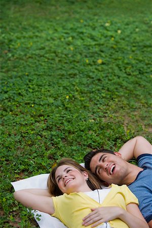simsearch:625-01746602,k - Vue grand angle sur un jeune couple se trouvant dans un parc et souriant Photographie de stock - Premium Libres de Droits, Code: 625-01746501