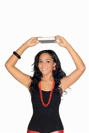 Portrait of a teenage girl holding a book above her head Stock Photo - Premium Royalty-Free, Code: 625-01746510