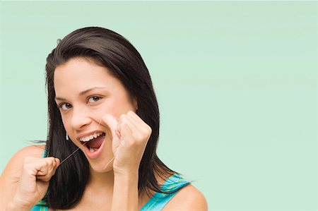 dental floss - Portrait of a young woman flossing her teeth Stock Photo - Premium Royalty-Free, Code: 625-01746513