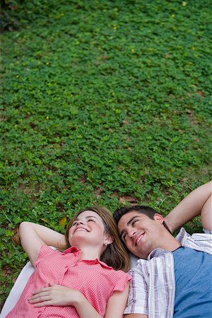 simsearch:625-01746733,k - Vue grand angle sur un jeune couple se trouvant dans un parc et souriant Photographie de stock - Premium Libres de Droits, Code: 625-01746522