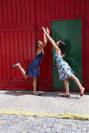 Side profile of two young women giving high- five to each other Stock Photo - Premium Royalty-Free, Code: 625-01746552