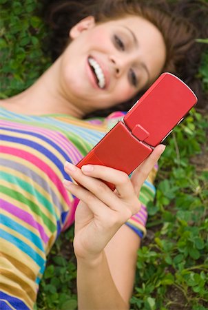 simsearch:625-00902766,k - High angle view of a young woman holding a mobile phone and smiling Foto de stock - Sin royalties Premium, Código: 625-01746574