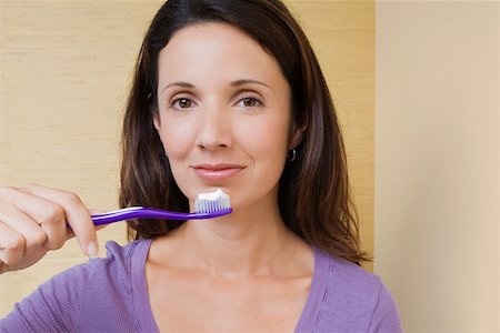 simsearch:625-01746587,k - Portrait d'une femme adulte mid tenir une brosse à dents devant sa bouche Photographie de stock - Premium Libres de Droits, Code: 625-01746615