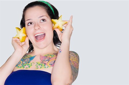 food tattoos - Close-up of a young woman holding star fruits Foto de stock - Sin royalties Premium, Código: 625-01746636