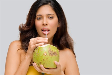 Portrait of a young woman drinking coconut milk Stock Photo - Premium Royalty-Free, Code: 625-01746656