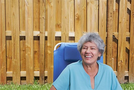 Senior woman sitting in a lawn chair and smiling Stock Photo - Premium Royalty-Free, Code: 625-01746671